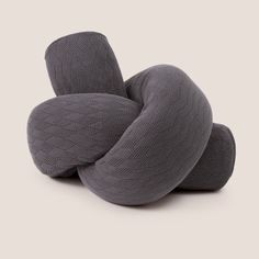 three gray pillows stacked on top of each other in the shape of an interlocked knot