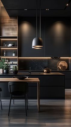 a modern kitchen with black cabinets and wood flooring is lit by pendant lights above the island