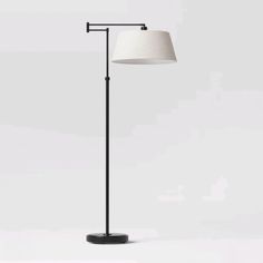 a black floor lamp with a white shade