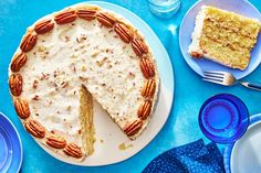 a cake with pecans on top and two slices cut from it next to plates