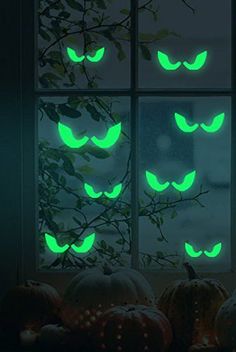 glow in the dark halloween window stickers with cats and pumpkins on them, set against a window sill