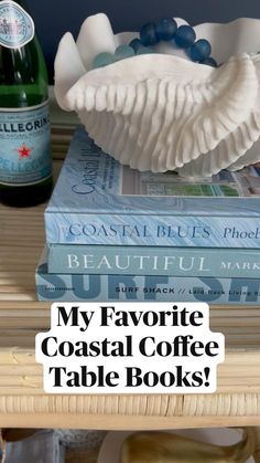 two books and a bottle on a table with text overlay that reads, my favorite coastal coffee table books