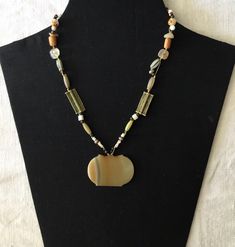 A necklace with  beautiful banded Agate Amulet  dating back 1,000 years and from Afghanistan. On one side the colour is a deep yellow orange while the other is a more milky fawn. The long rectangles are brass beads from Ghana and are made by hand using the lost wax process. Other beads in the strand include antique Venetian glass and other stone silver and glass beads. Large Sterling Silver Hook Clasp Agate is the name given to numerous varieties of banded Chalcedony, a mineral of the Quartz fam Bohemian Brown Rectangular Necklace, Unique Rectangular Necklaces With Natural Stones, Unique Rectangular Natural Stone Necklace, Rectangular Natural Stones Necklace For Healing, Rectangular Agate Necklace With Natural Stones, Spiritual Rectangular Natural Stones Necklaces, Textile Necklace, Deep Yellow, Brass Beads