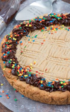 a cookie cake with chocolate frosting and sprinkles