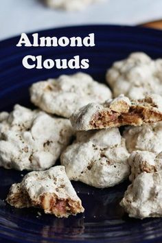 a blue plate topped with cookies covered in powdered sugar and text that reads almond clouds