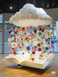 an open book with paper flowers hanging from it