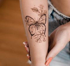 a woman's arm with a butterfly tattoo on it