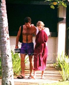 the man and woman are walking down the path together in their bathing suits with towels on