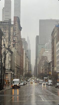 a city street filled with lots of traffic on a foggy day in the middle of winter