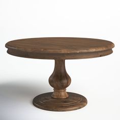 a round wooden table sitting on top of a white floor