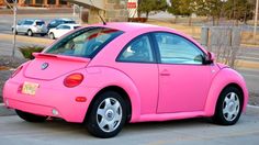 a pink car is parked on the side of the road