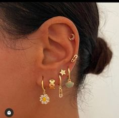 a close up of a person's ear with three different types of earrings on it