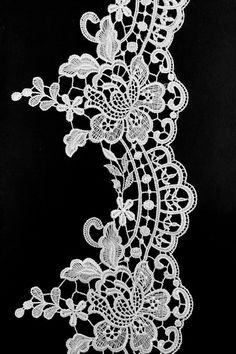 a white lace with flowers and leaves is shown on a black background in this image