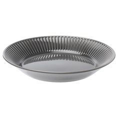 a large metal bowl sitting on top of a white tablecloth covered plate with pleated edges