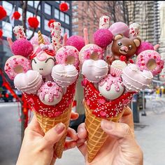 someone holding up two ice cream cones decorated with teddy bears