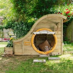 a dog house made out of wood in the yard