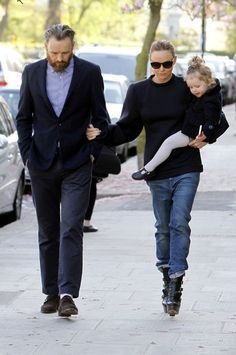 a man and woman walking down the street with a child