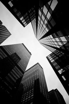 looking up at skyscrapers from below in black and white