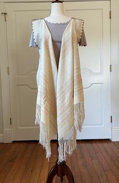 Elevate your outfit with this open front, Rebozo, fringed vest!! perfect for all occasions. Wear with any top or dress and any sleeve length.  Would be stunning over a bathing suit while vacationing or at home at the pool. let your imagination run wild to update your wardrobe.  Mexican Rebozo, shawl was woven on a traditional a pedal loom with 100 % cotton and silk trades in the state of Oaxaca Mexico.  Measures approximately: 98" Length (including Fringes) x 26" Width PC # B-726 PLEASE NOTE: Th Fringed Shawl For Summer Festivals, Summer Shawl With Fringe, Summer Fringe Shawl, Bohemian Fringe Shawl For Spring, Spring Shawl With Tassels, Bohemian Fringe Vest For Festivals, Bohemian Beige Shawl With Fringe, Beige Bohemian Shawl With Fringe, Bohemian Fringe Vest