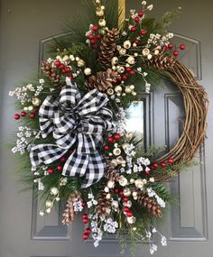 a christmas wreath with pine cones and berries