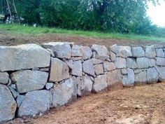 a large rock wall in the middle of a field