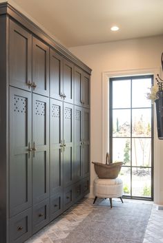 a large gray armoire sitting next to a window in a room with a rug on the floor