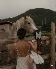 a mother and her daughter petting a horse