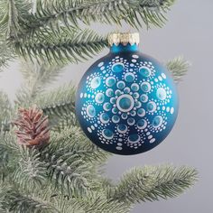 a blue ornament hanging from a christmas tree