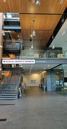 the inside of an office building with stairs and railings leading up to two floors