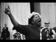 a woman is singing in front of a crowd