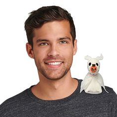 a man holding a stuffed animal in front of his face and smiling at the camera