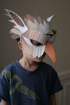 a young boy wearing a paper mask made to look like a bird