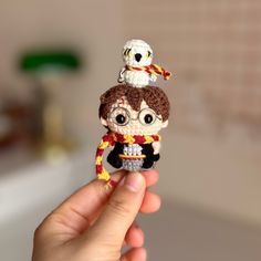 a person holding up a tiny doll in their hand