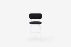 a black and white bar stool against a white background with the seat upholstered