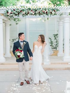 a bride and groom hold hands as they walk down the aisle