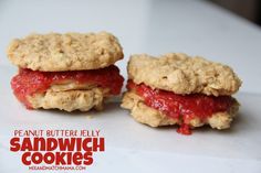 two peanut butter jelly sandwich cookies sitting on top of a white table next to each other