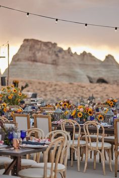 an outdoor dining area with wooden tables and chairs, sunflowers on the table