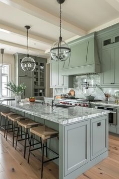 a large kitchen with an island in the middle and four stools at the end