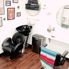 a chair and sink in a room with pictures on the wall above it that is also used as a hair salon