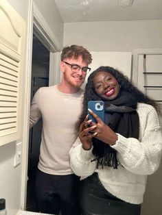 a man and woman taking a selfie in the bathroom