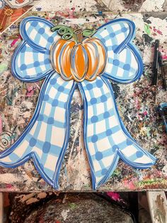 a blue and white bow with pumpkins on it sitting on a piece of paper