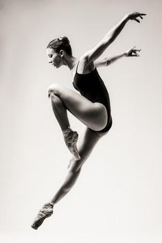 a woman in a black leotard doing a trick