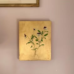 a painting hanging on the wall next to a clock and vase with flowers in it