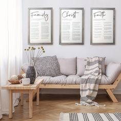 a living room filled with furniture and two framed posters on the wall above the couch