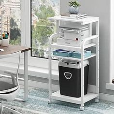 a computer desk with a laptop on top of it next to a chair and window