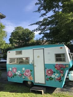 a blue and white trailer with flowers painted on it