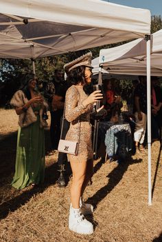 a woman standing under a tent holding a camera