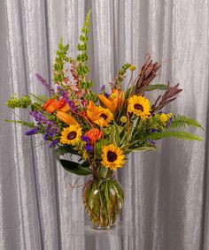 a vase filled with lots of different types of flowers