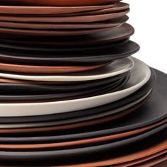 a stack of black and brown plates stacked on top of each other with white rims