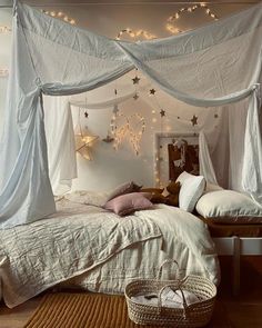 a bed with white drapes and lights hanging from the ceiling